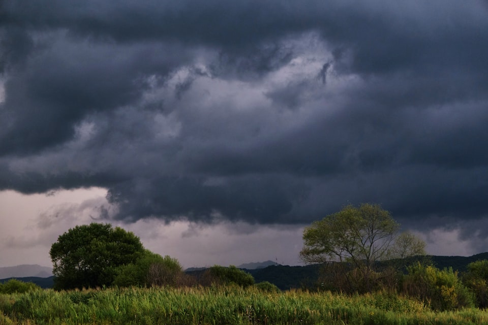 Dark storm clouds gathering over open countryside near a UK campsite