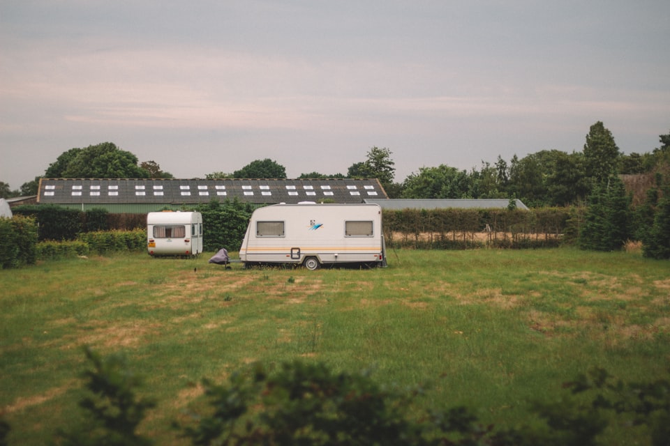 Two touring caravans pitched on a grass field at a small UK farm site