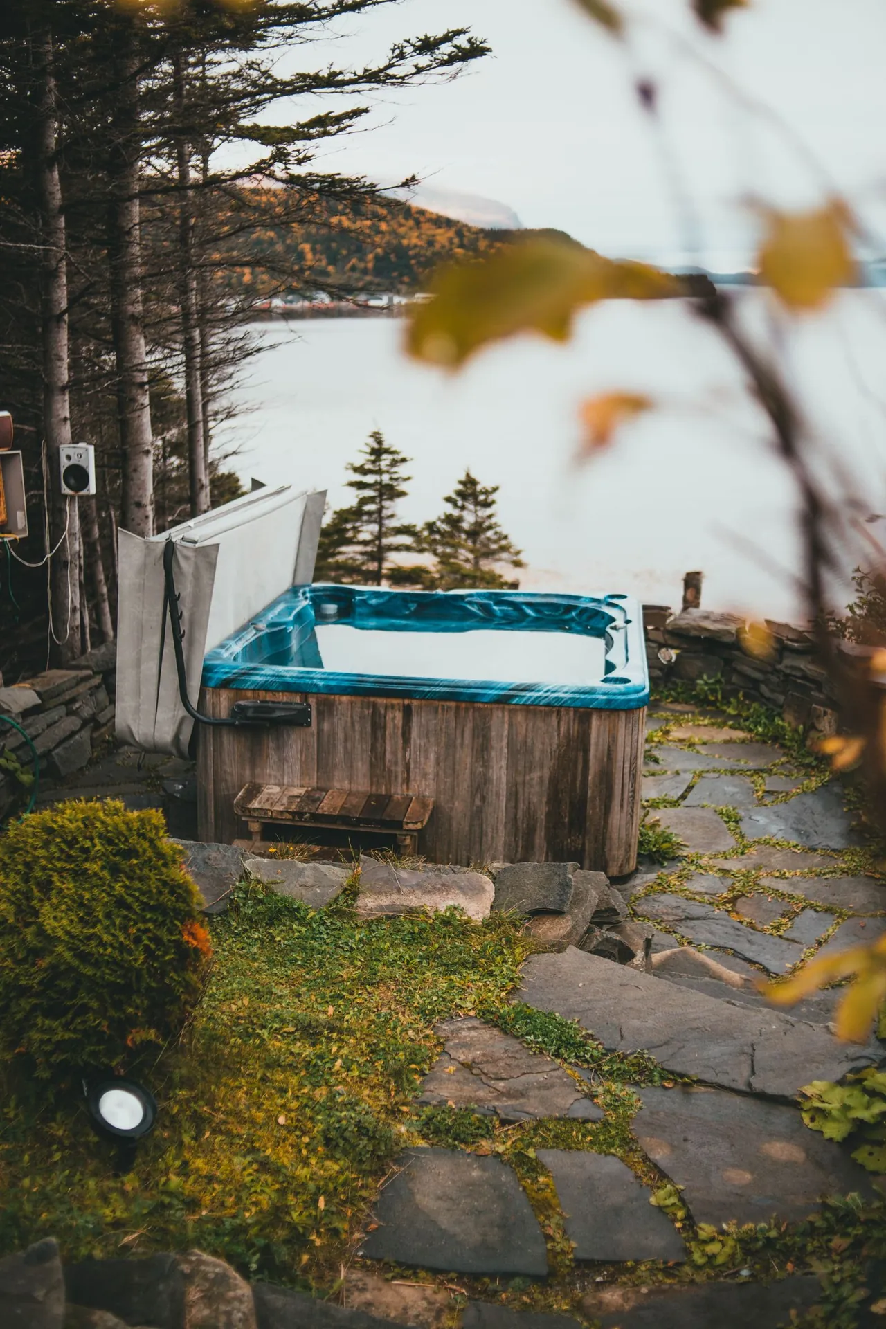 An outdoor hot tub on a lodge deck overlooking a lake